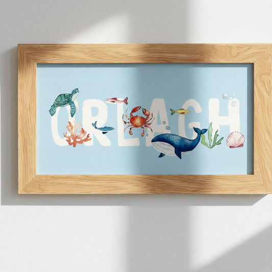 School Bus Studio custom Under the Sea name print in an oak frame featuring watercolor sea creatures on blue card.