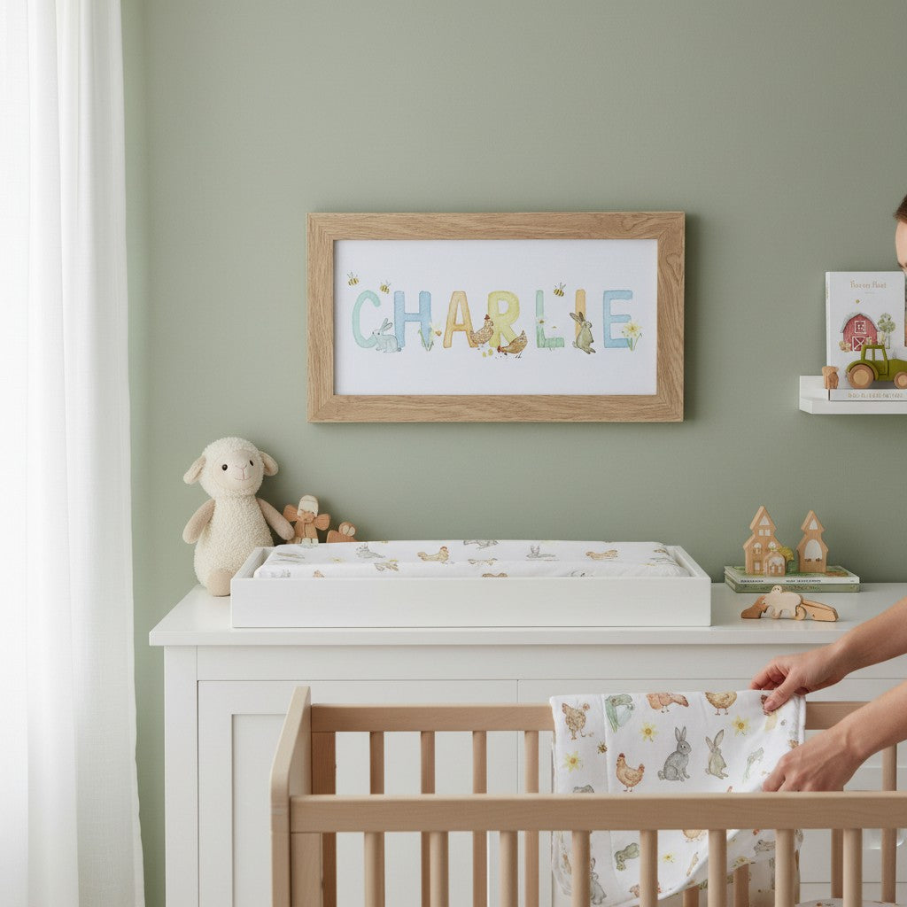 School Bus Studio custom name print in oak frame featuring Irish countryside watercolor animals in a nursery room.