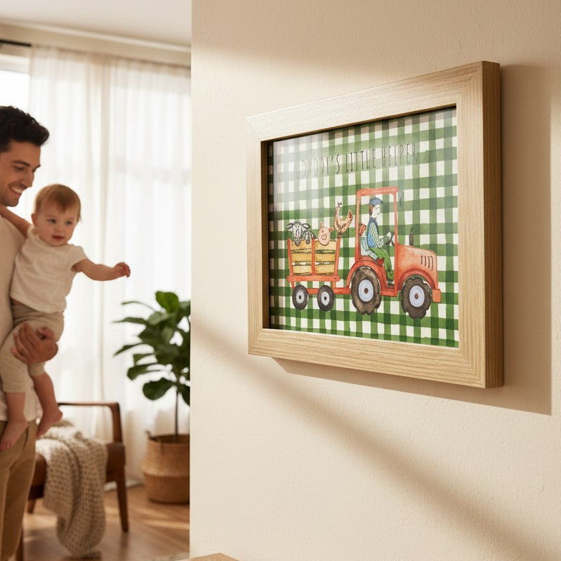 School Bus Studio Daddy's Little Helper A4 red tractor print in an oak frame hanging on a wall near a father and baby.