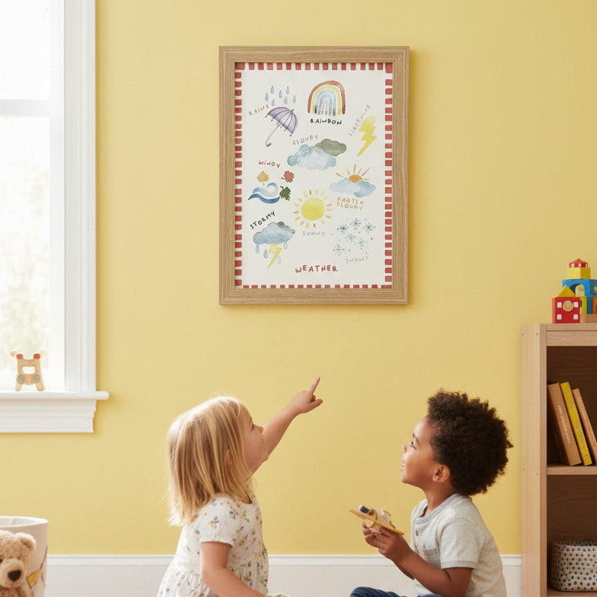 School Bus Studio A3 weather wall art print in an oak frame hanging in a colorful nursery with two children playing.